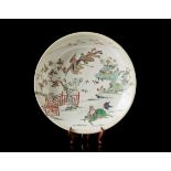 A Famille Verte porcelain dish decorated with a qilin, with wood support (defects and restorations)