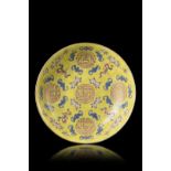 A yellow-ground Famille Rose dish decorated with shou characters, peaches and bats, Tongzhi four