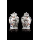 A pair of baluster jars and covers each decorated in Famille Rose with boys in a processionChina,