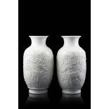 A pair of white porcelain cylindrical vases, each decorated in relief with deer amongst pine