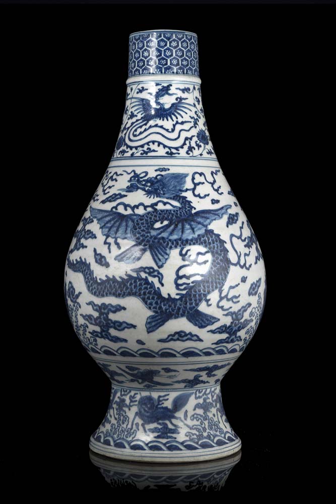 A blue and white Ming-style vase decorated with a winged dragon amongst clouds, a phoenix and