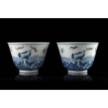 A pair of blue and white cups decorated with the foaming waves motif and flying auspicious bats