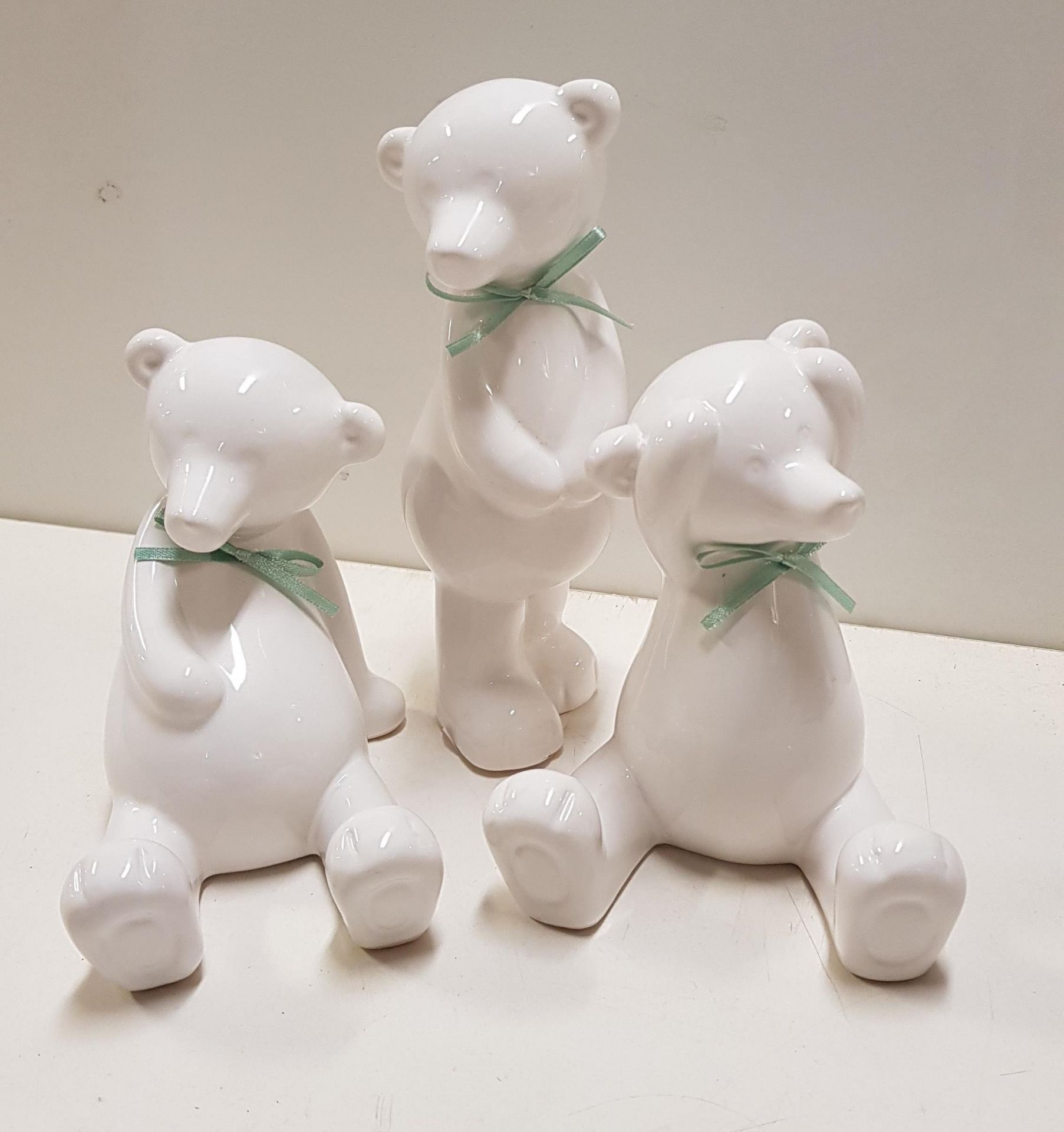 48 x White ceramic bears with green bows.