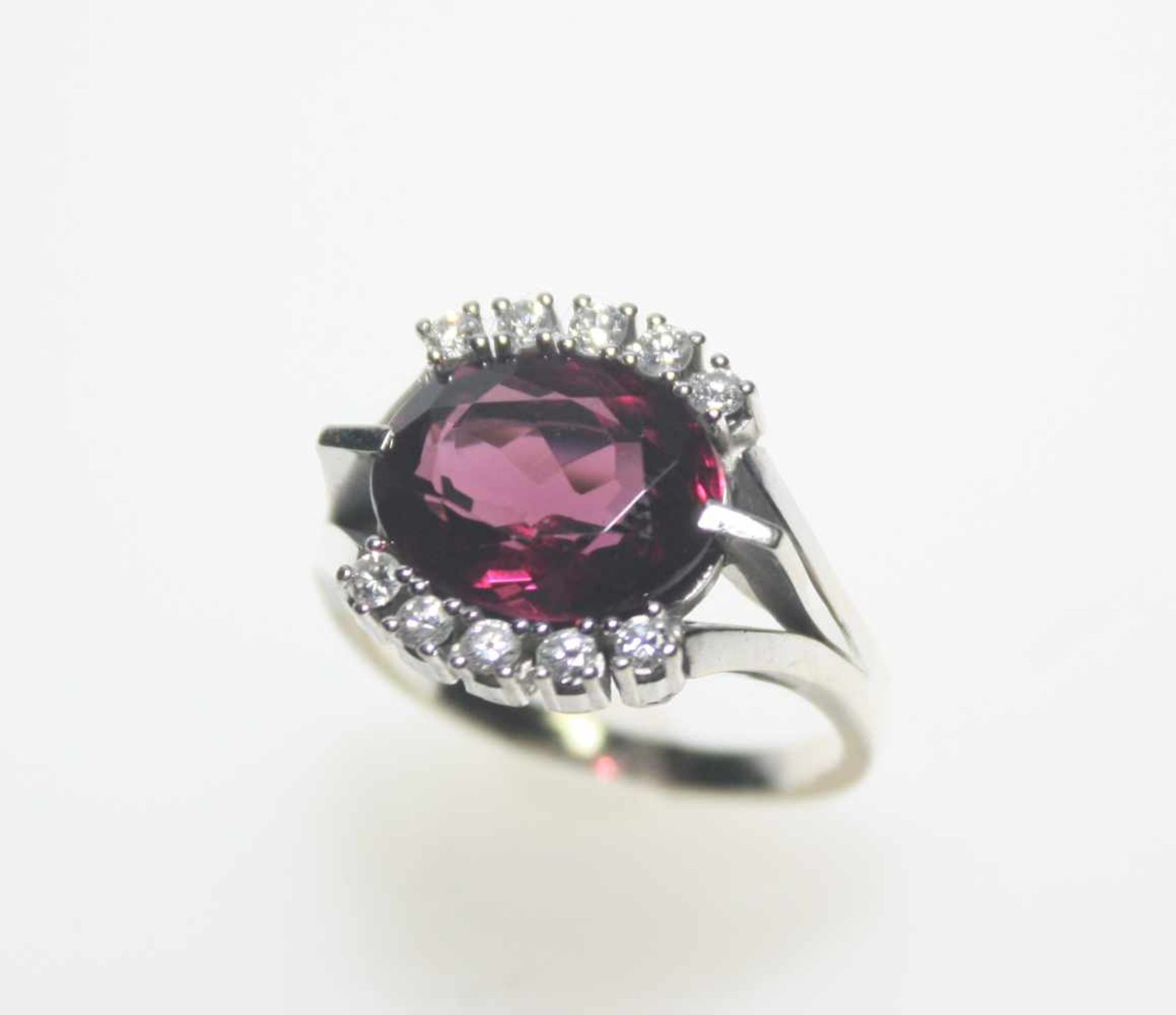 Weißgoldring 585/f gest. mit einem rot/violetten Stein, oval facettiert und Diamanten in