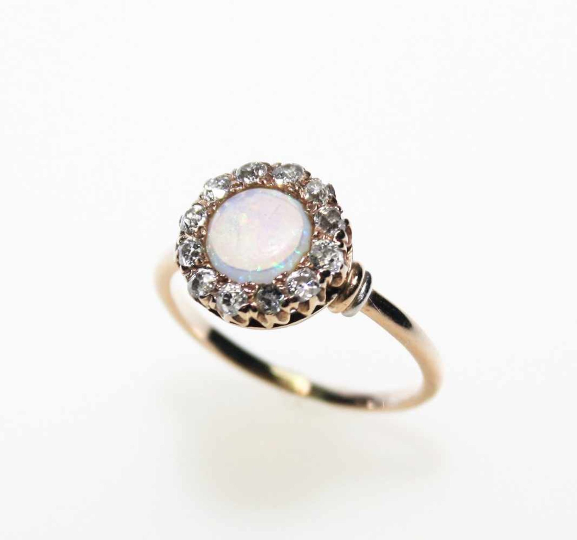 Älterer, schmaler Goldring ca. 585/f gest. mit einem hellen, runden Opal umgeben von Diamanten in