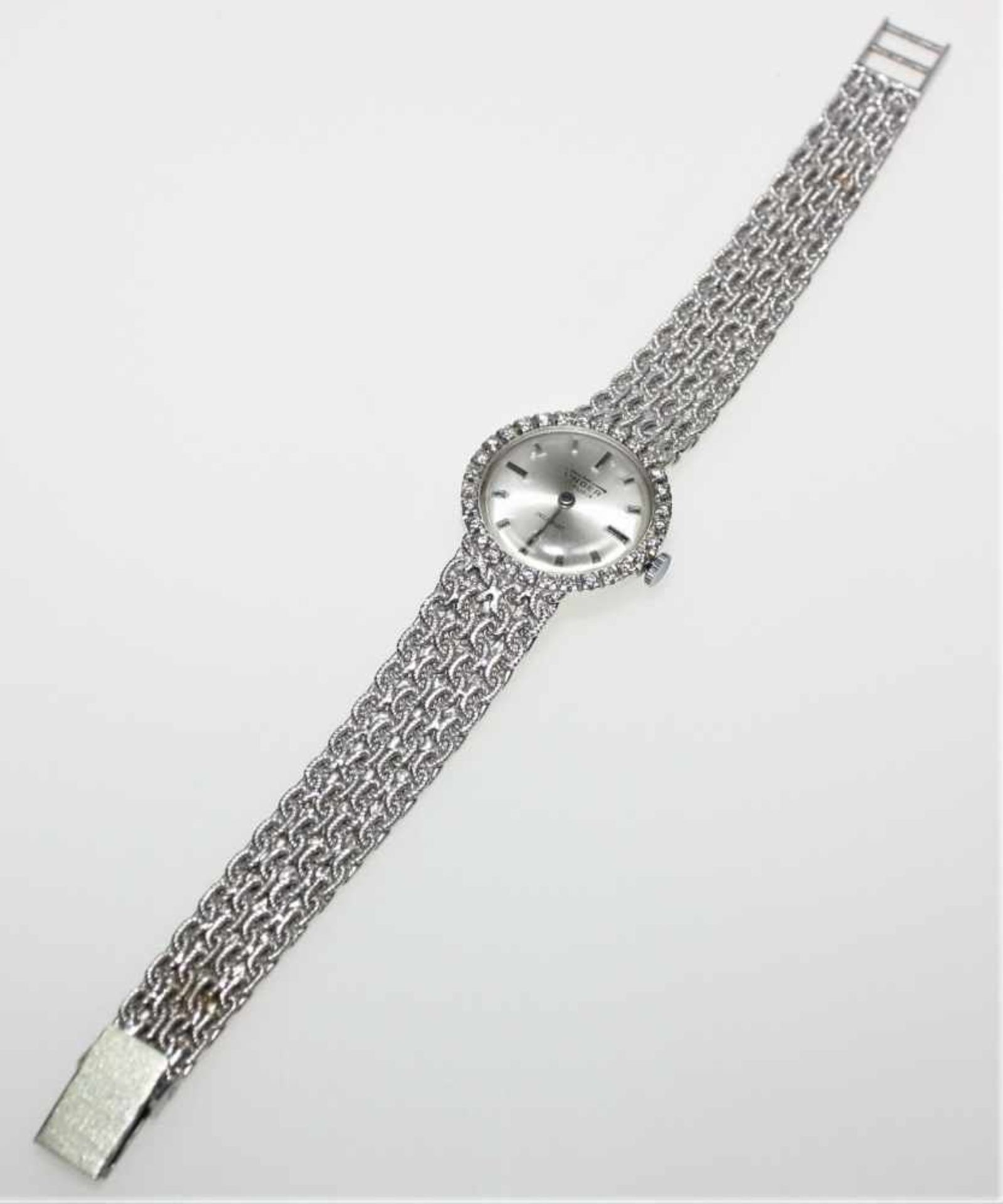 Weißgoldene Damen-Armbanduhr mit fest angearbeitetem Ansatzband 750/f gest., rundes Zifferblatt