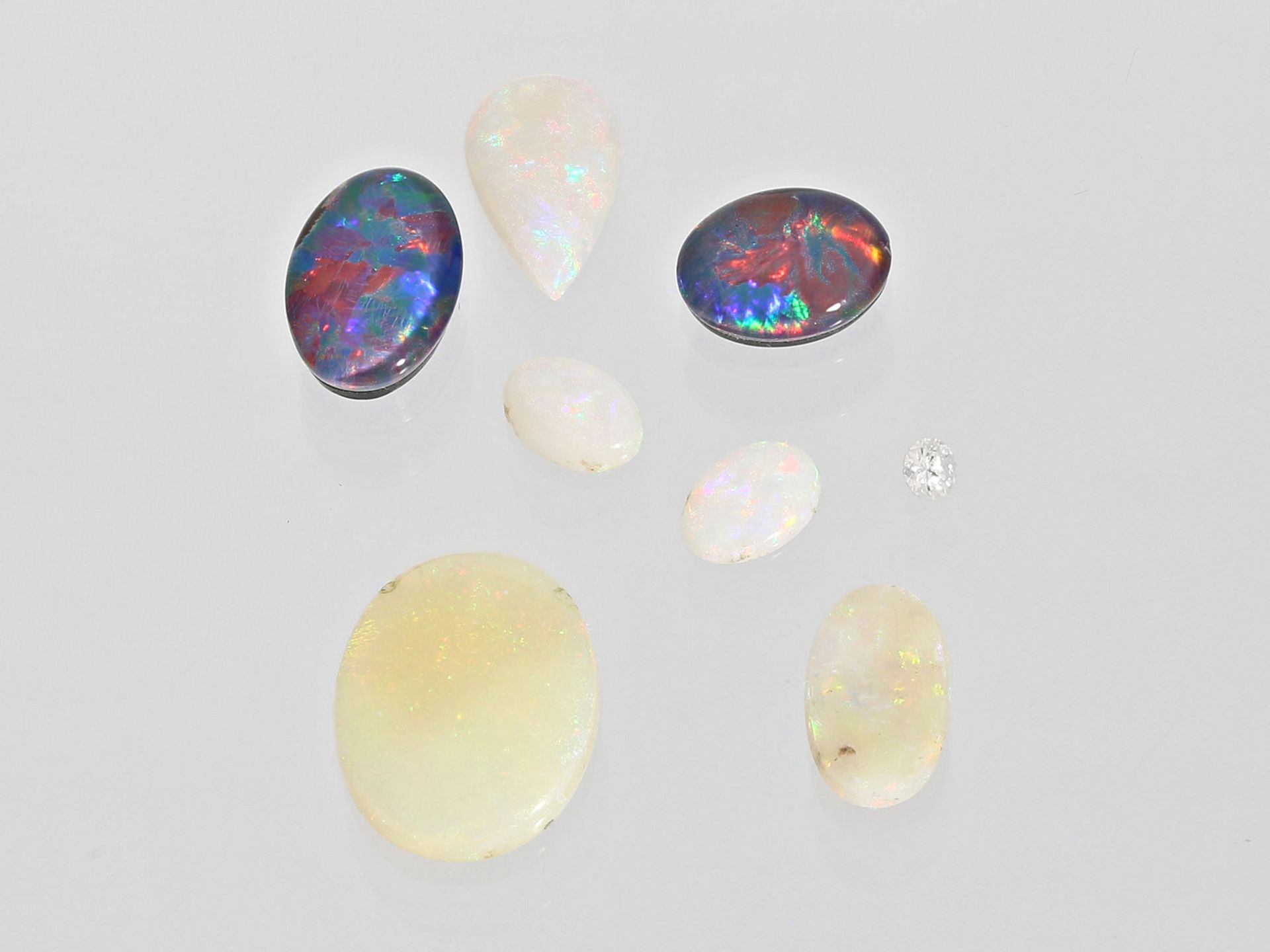 Opal/Brillant: Konvolut verschiedenfarbiger Opale sowie ein kleiner BrillantBestehend aus 6 ovalen