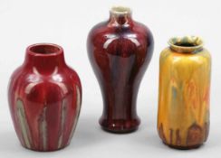 3 Vasen mit LaufglasurEngland u.a. Keramik, heller Scherben. Laufglasur in Rot-grün. H. 14 cm. -