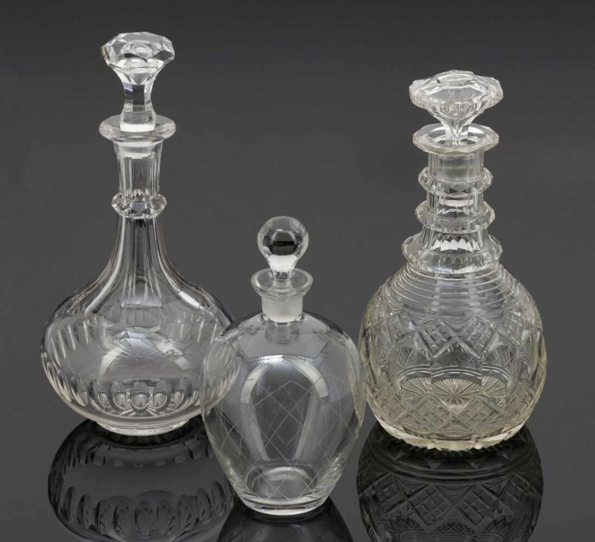 3 unterschiedliche Karaffen mit StöpselnFarbloses Glas. 1 Karaffe. Um 1900. Facettiert. H. 27,5