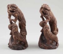Paar Fo-HundeChina, um 1900. Holz. Reste von Goldbemalung. H. 26 cm. - Zustand: Eine Figur mit