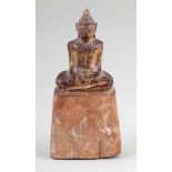 BuddhaBurma, um 1900. Holz.Vergoldet. H. 15,5 cm. Auf hohem Sockel sitzend mit den Händen im Schoß.
