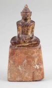 BuddhaBurma, um 1900. Holz.Vergoldet. H. 15,5 cm. Auf hohem Sockel sitzend mit den Händen im Schoß.