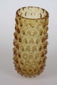 Vase mit NuppenBernsteinfarbiges Glas. Ausgeschliffener Abriss. H. 23,5cm, D. der Öffnung: 9 cm.