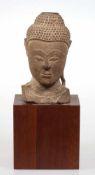 Buddha KopfThailand, Ayutthaya. Stein. H. o./m. Sockel 20/35 cm. Ushnisha fehlt. Rechtes Ohr ber.