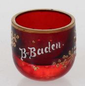 Kleiner Schnapsbecher B-BadenUm 1890. Farbloses Glas, rot lasiert. Gold und opakweiße