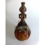 Kalebasse, wohl Baule, Holz, Federn und Pflanzenfaser, weibliche Halbfigur, l. 24cm,Provenienz: