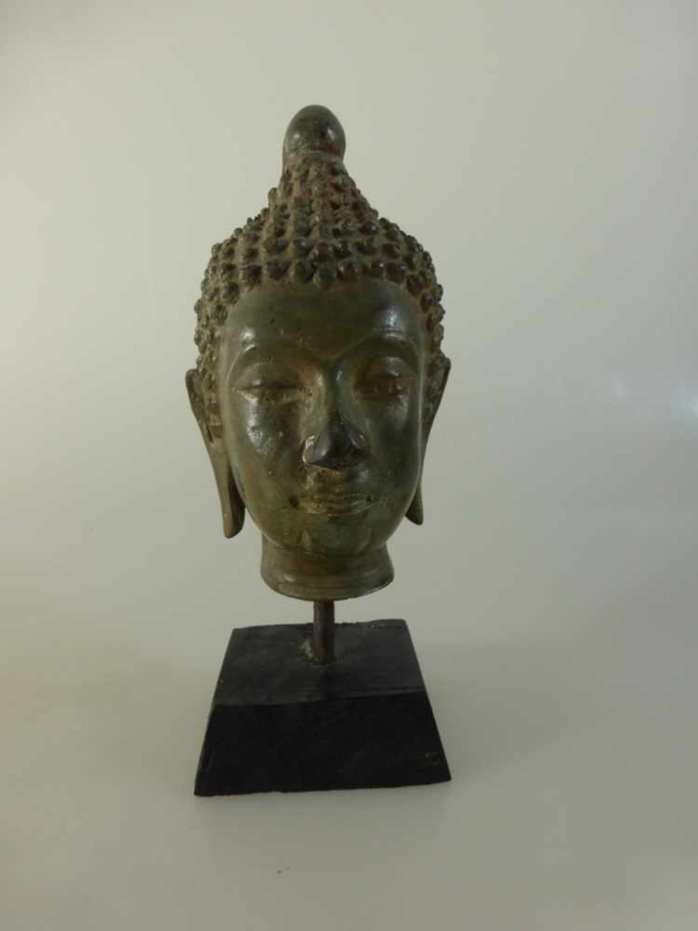 Buddhakopf, Thailand, Metallguss auf Holzständer mont., h. 16cm- - -18.00 % buyer's premium on the