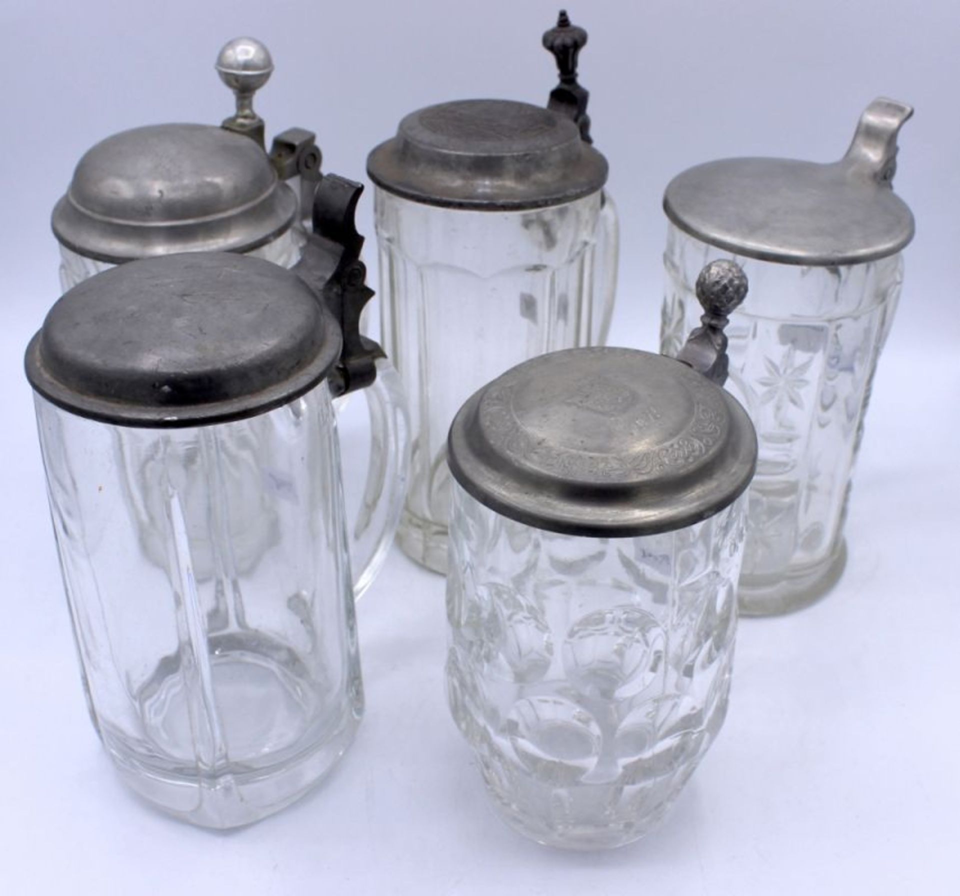 Lot von 5 Bierkrügen 0,4-0,5 L., Zinndeckel, Glas, Altersspuren, Höhe ca. 18-21,5 cm, A.