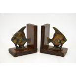 A pair of bronze and oak Art Deco book ends