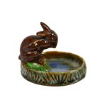 A Doulton Lambeth stoneware bibelot by Harry Simeon, a rabbit on a rocky outcrop