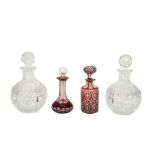 A pair of cut glass decanters, together with a ruby cased cut glass scent bottle and another