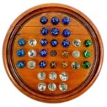 A small fruitwood? solitaire board with 32 mica marbles in amber, clear, blue and green glass 13 to