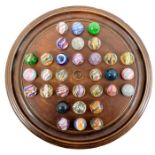 A solitaire board with 32 large glass marbles, including onionskins, two with mica, single pontil tr