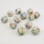 A cotton draw string bag containing ten large unglazed china marbles, in lined helix patterns, plus