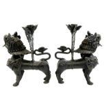 A pair of Oriental bronze candle sticks, modelled as Chinese lions