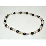 A grey and white freshwater pearl necklace approx. 8 – 8.5mm threaded onto a 18ct white gold clasp
