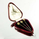 A cased set of three yellow gold gem set shield stickpins