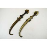 Two Arabic Jambiya daggers, housed in gilt metal scabbards, wooden grips, 41cm long (2)