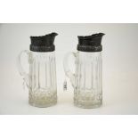 A pair of white metal mounted cut glass beer or lemonade jugs