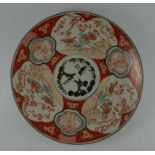 An Imari charger, decorated with garden scenes, together with seven similar plates, charger 45cm dia