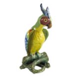 Fourmaintraux Courquin Desvres, a faience pottery figure of a parrot, glass eyes, perched on a tree