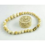 A 19th century Chinese carved ivory box and a graduated bead necklace