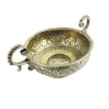 An 18th century two handled white metal bowl, the base set with a Queen Anne silver shilling, 1711,