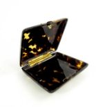 A yellow metal mounted tortoiseshell cigarette case