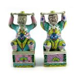 A pair of Chinese polychrome figures with raised arms.