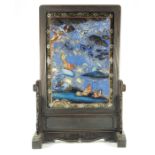 A Chinese hardwood reverse painted glass and mirrored fire screen