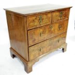 A George II walnut veneered chest of two short over two long graduated drawers