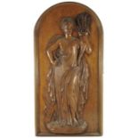 A 19th century carved oak panel of Ruth in the Cornfield, modelled in relief, within a rounded arcad