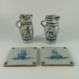 Two Dultch Delft tiles and a pair of Delft blue and white jugs