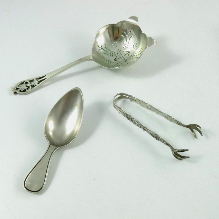 An Elizabeth II silver tea strainer, Edward Viner, caddy spoon and sugar tongs
