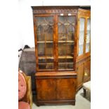 A display cabinet with glass doors above two cupboard doors, height, 183cm