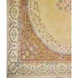 A large Persian style cream ground carpet with floral decoration
