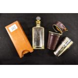 A leather cased spirit flask with a cased set of six silver plated beakers (2)