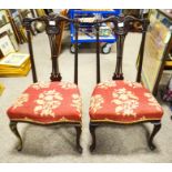 A pair of dining chairs with upholstered seats