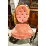 A Victorian carved walnut and upholstered chair, circa 1860, button upholstery. Height 94cm