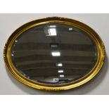 An oval mirror with a gilt frame 59cm x 79cm